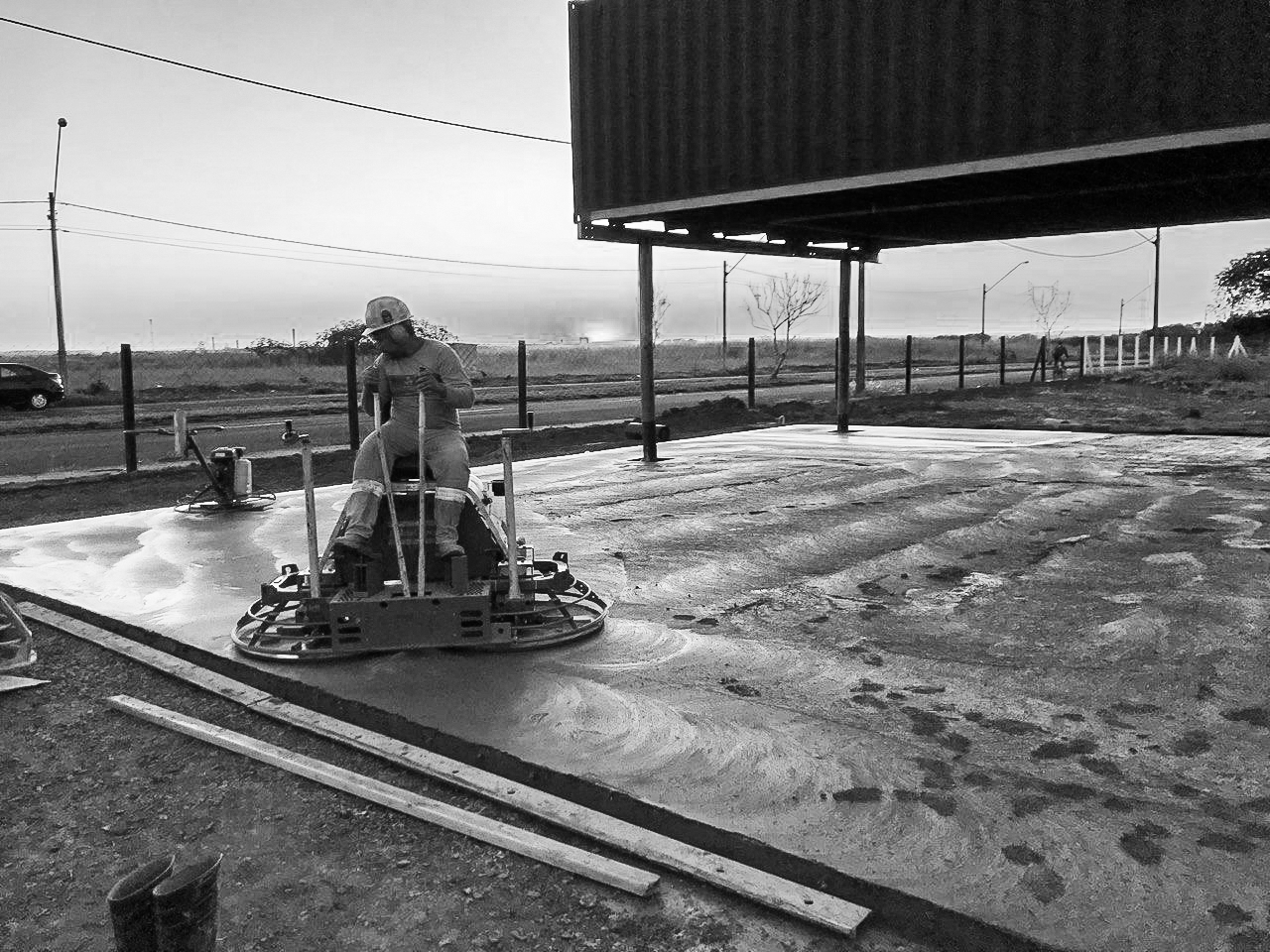 Executor acabando um piso de concreto com acabadora de superfície